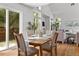 Bright dining area with light hardwood floors, a modern table setting, and natural light from the large windows and door at 1359 S Beeler Ct, Denver, CO 80247