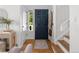 Bright entryway with hardwood floors, stylish blue door, and staircase access at 1359 S Beeler Ct, Denver, CO 80247