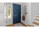 Well-lit entryway featuring a stylish blue door, hardwood floors, and convenient coat hooks at 1359 S Beeler Ct, Denver, CO 80247