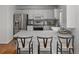 Bright kitchen featuring stainless steel appliances, white cabinets, gray countertop, and barstool seating at 1359 S Beeler Ct, Denver, CO 80247