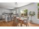 Open-concept kitchen and dining area with white cabinets, stainless steel appliances, and wood floors at 1359 S Beeler Ct, Denver, CO 80247