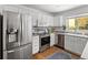 Bright kitchen featuring stainless steel appliances, white cabinetry, light countertop, and a tiled backsplash at 1359 S Beeler Ct, Denver, CO 80247