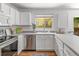 White kitchen with stainless steel appliances, light countertops, and a window providing natural light above the sink at 1359 S Beeler Ct, Denver, CO 80247
