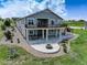 Rear exterior of home featuring a large deck, a stone patio with fire pit, and a hot tub at 2504 Elkhorn Ranch St, Parker, CO 80138