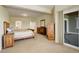 Spacious bedroom with light-tone walls, carpet, and wooden furniture, next to an outdoor patio space at 2504 Elkhorn Ranch St, Parker, CO 80138