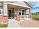 Inviting front porch with brick columns and charming white railing at 2504 Elkhorn Ranch St, Parker, CO 80138