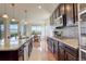 Eat in kitchen with granite countertops, stainless steel appliances, dark wood cabinetry, and dining area at 2504 Elkhorn Ranch St, Parker, CO 80138