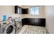Practical laundry room with washer, dryer, storage cabinets, and counter space at 2504 Elkhorn Ranch St, Parker, CO 80138