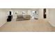 Open living room with neutral carpet, couches and large windows, connecting to dining and kitchen space at 2504 Elkhorn Ranch St, Parker, CO 80138