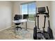 Cozy office space bathed in natural light, complete with desk, chair, and fitness machine at 2504 Elkhorn Ranch St, Parker, CO 80138