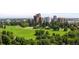 Lush park with mature trees, a walking path and city buildings in the background at 1500 E 7Th Ave, Denver, CO 80218