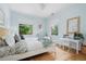 Bedroom with a wooden desk, plush rug, and two windows with views of the surrounding greenery at 1500 E 7Th Ave, Denver, CO 80218
