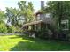 Charming home exterior with a lush green lawn and mature trees, showcasing curb appeal at 1500 E 7Th Ave, Denver, CO 80218