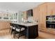 Bright kitchen with natural wood cabinets, black island, and stainless steel appliances at 1500 E 7Th Ave, Denver, CO 80218