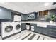 Well-organized laundry room with modern washer and dryer, blue cabinets, sink and ample counter space at 1500 E 7Th Ave, Denver, CO 80218