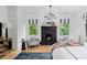 Bright main bedroom featuring hardwood floors, a fireplace, and two sitting chairs at 1500 E 7Th Ave, Denver, CO 80218