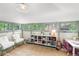 Bright playroom with charming design, shelving units, two white fur chairs, a desk and neutral colored rug at 1500 E 7Th Ave, Denver, CO 80218