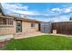 Private backyard boasts artificial turf, stone paver patio, storage shed, and a wooden fence at 2461 Yates St, Denver, CO 80212
