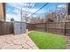 Private backyard boasts artificial turf, stone paver patio, storage shed, and a wooden fence at 2461 Yates St, Denver, CO 80212