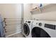 Efficient laundry room with front load washer, front load dryer, overhead storage and drying rack at 8863 Osceola St, Westminster, CO 80031