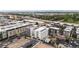 Expansive aerial view of modern residential buildings surrounded by lush greenery and cityscape, showcasing the community's layout at 1898 S Bannock St # 202, Denver, CO 80223