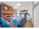 Stylish bedroom featuring a cozy bed, brick accent wall with fireplace and mountain themed artwork at 1898 S Bannock St # 202, Denver, CO 80223