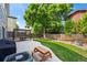 Backyard with pergola over patio, lush lawn, wood picnic table, and mature shade tree at 4975 S Zephyr St, Littleton, CO 80123