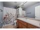 Well-lit bathroom featuring a floral shower curtain, vanity with ample storage, and a clean, inviting atmosphere at 4975 S Zephyr St, Littleton, CO 80123