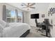 Comfortable bedroom with large window, ceiling fan, and dedicated workspace for optimal productivity at 4975 S Zephyr St, Littleton, CO 80123