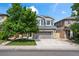 Charming two-story home with gray siding, a well-manicured lawn, and a two car garage at 4975 S Zephyr St, Littleton, CO 80123