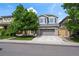 Charming two-story home with gray siding, a well-manicured lawn, and a two car garage at 4975 S Zephyr St, Littleton, CO 80123