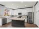 Modern kitchen features white cabinets, stainless steel appliances, and center island with butcher block countertop at 4975 S Zephyr St, Littleton, CO 80123
