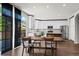 Bright kitchen with white cabinets, stainless steel appliances, island, and dining area with outside view at 4975 S Zephyr St, Littleton, CO 80123