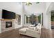 Bright living room boasting a fireplace, ceiling fan, large windows, and comfortable seating at 4975 S Zephyr St, Littleton, CO 80123