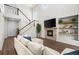Sun-filled living room featuring a fireplace, TV, and hardwood floors, and a large couch at 4975 S Zephyr St, Littleton, CO 80123