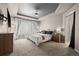 Spacious main bedroom with tray ceiling, neutral carpet, generous light, and an ensuite entrance at 4975 S Zephyr St, Littleton, CO 80123
