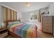 Bright bedroom featuring a colorful striped comforter, wooden bed frame, and natural light at 19688 E Lasalle Dr, Aurora, CO 80013