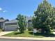 Well-kept home with mature trees, green lawn, and a 'For Sale' sign, located on a quiet street at 19688 E Lasalle Dr, Aurora, CO 80013