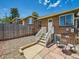 Brick home with a white door, staircase, and small stone patio with black metal table at 4418 W 11Th Ave, Denver, CO 80204
