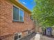Red brick wall with two larger windows and two smaller windows at ground level at 4418 W 11Th Ave, Denver, CO 80204