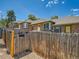 Exterior shot of three brick townhomes with wood fences and a blue sky at 4418 W 11Th Ave, Denver, CO 80204