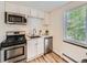 Well-lit kitchen with stainless steel appliances, white cabinets, and a window providing natural light at 4418 W 11Th Ave, Denver, CO 80204