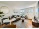 Comfortable living room features a gray sofa, stylish decor, hardwood floors, and a bright window at 4418 W 11Th Ave, Denver, CO 80204