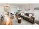 Inviting living room with a plush gray sofa, stylish decor, a round table, and hardwood floors at 4418 W 11Th Ave, Denver, CO 80204