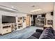 Spacious basement rec room with built-in storage and entertainment area with blue carpet at 9456 Bexley Dr, Highlands Ranch, CO 80126