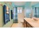 Bathroom features neutral counter, a large mirror and is painted with bright teal walls at 9456 Bexley Dr, Highlands Ranch, CO 80126