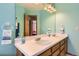 Bright bathroom features a double sink vanity, stylish lighting, and blue paint at 9456 Bexley Dr, Highlands Ranch, CO 80126