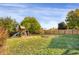 Fenced backyard with grassy lawn and playset at 21787 Unbridled Ave, Parker, CO 80138