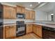 Modern kitchen with wood cabinets, black appliances, and a breakfast bar at 750 Vista Verde Hts, Monument, CO 80132