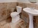Cozy half bathroom with decorative tile walls, pedestal sink, and updated toilet at 2631 E 136Th Pl, Thornton, CO 80602